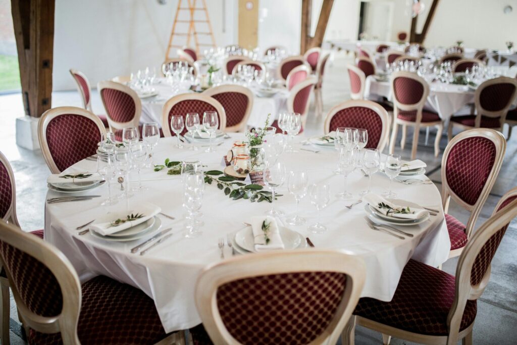 Beautifully arranged dining tables prepared for a formal wedding reception indoors.