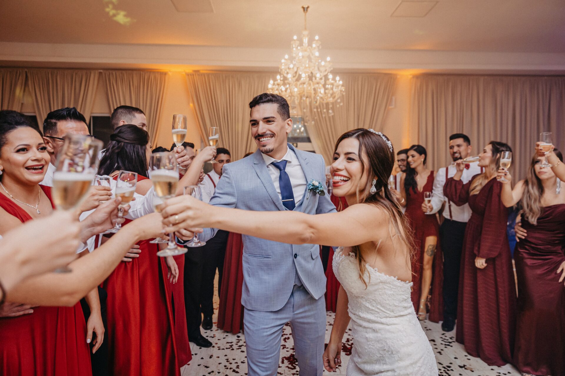 Home 18 Happy couple and guests raise glasses for a joyful wedding toast indoors.