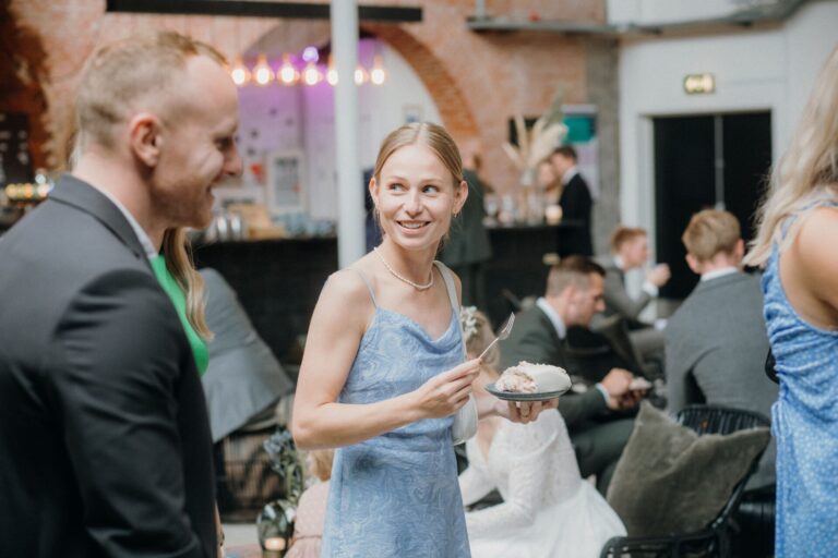 Guests enjoying a cheerful indoor celebration with cake and conversation.