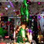 Festive birthday celebration with balloons, cake, and colorful confetti, highlighting a joyful atmosphere indoors.