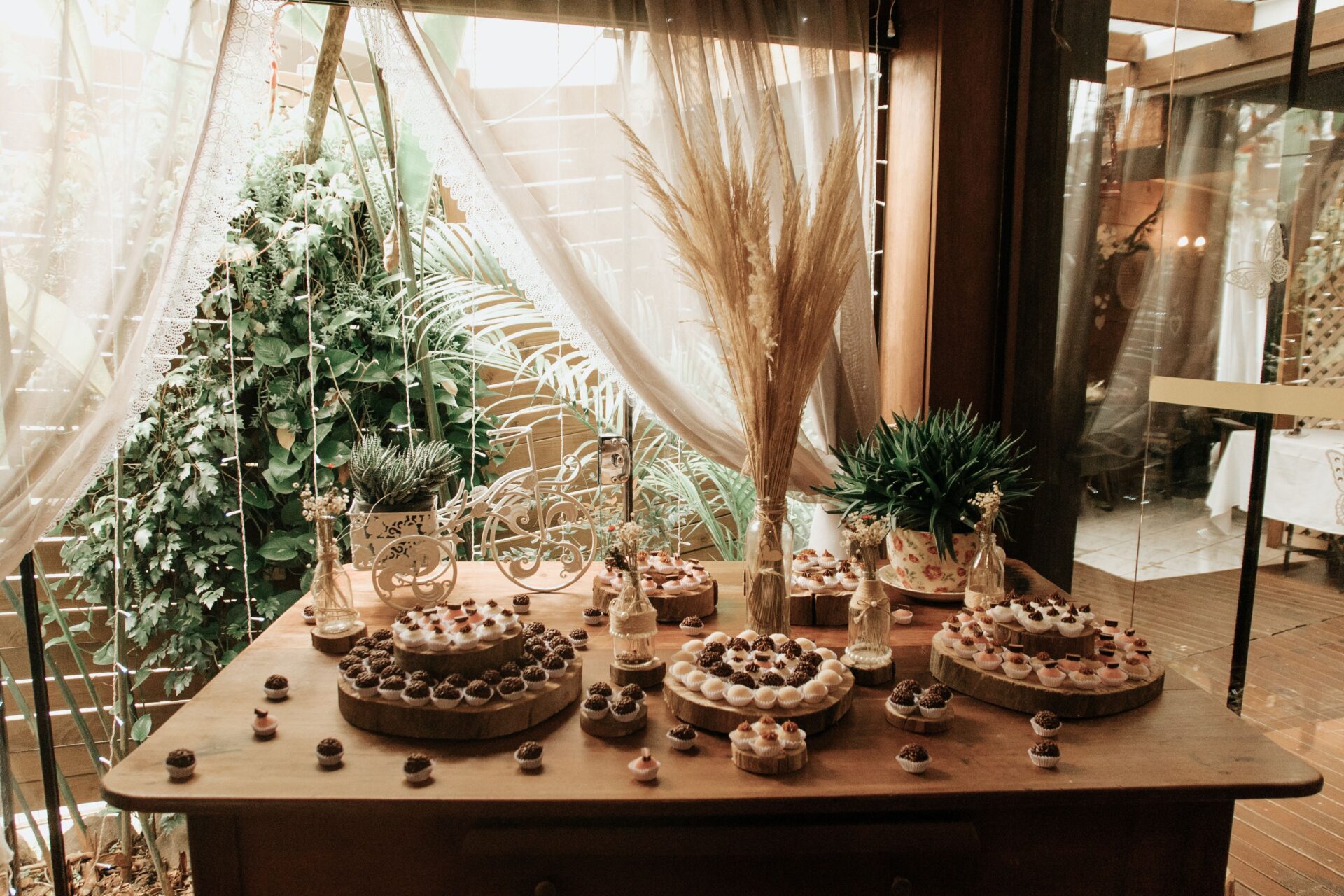 Elegant rustic dessert table featuring various sweet treats and natural decorations.