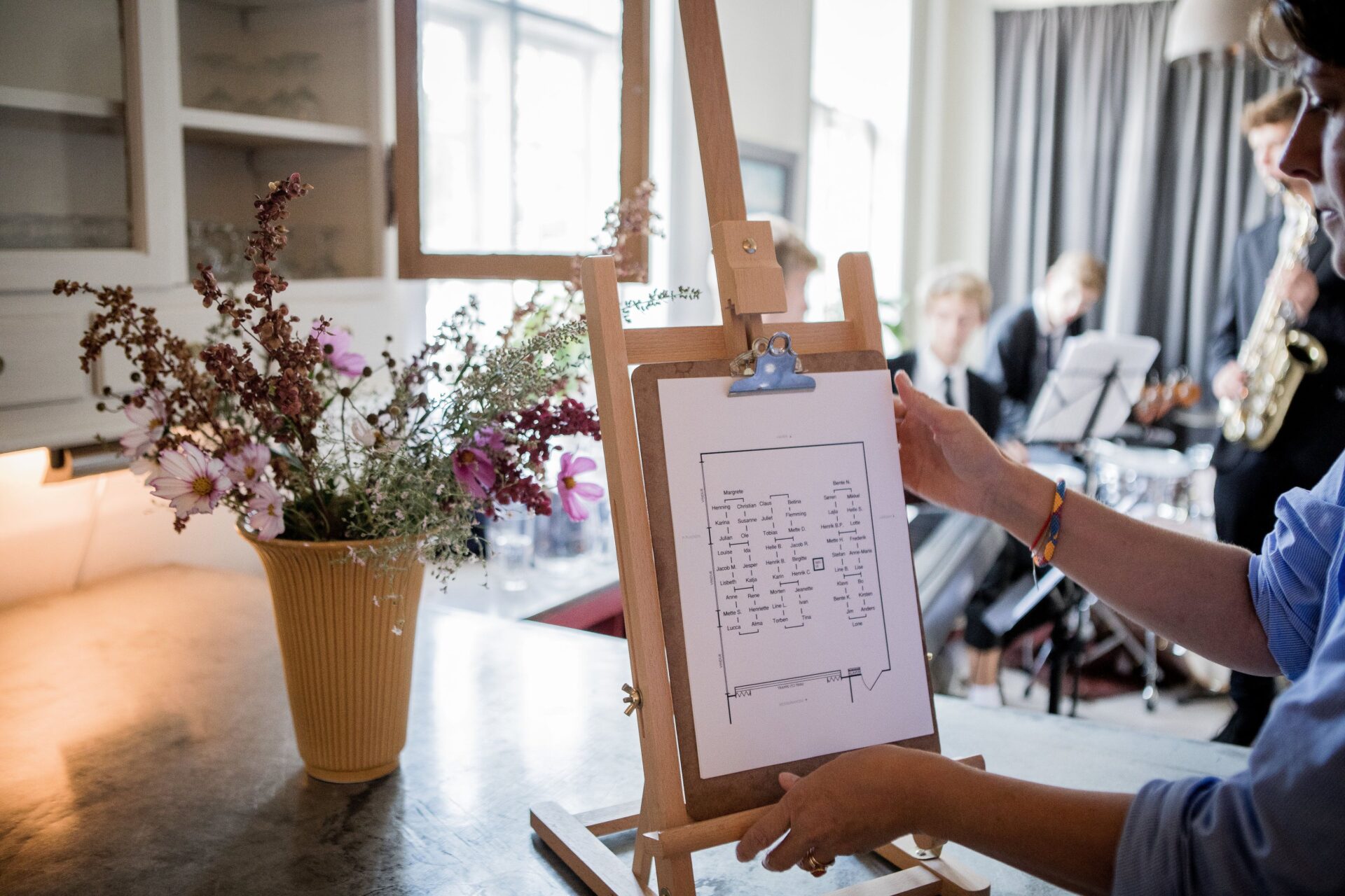 Templates 3 Musicians rehearsing indoors with an easel displaying a chart and floral decor creating an artistic ambiance.