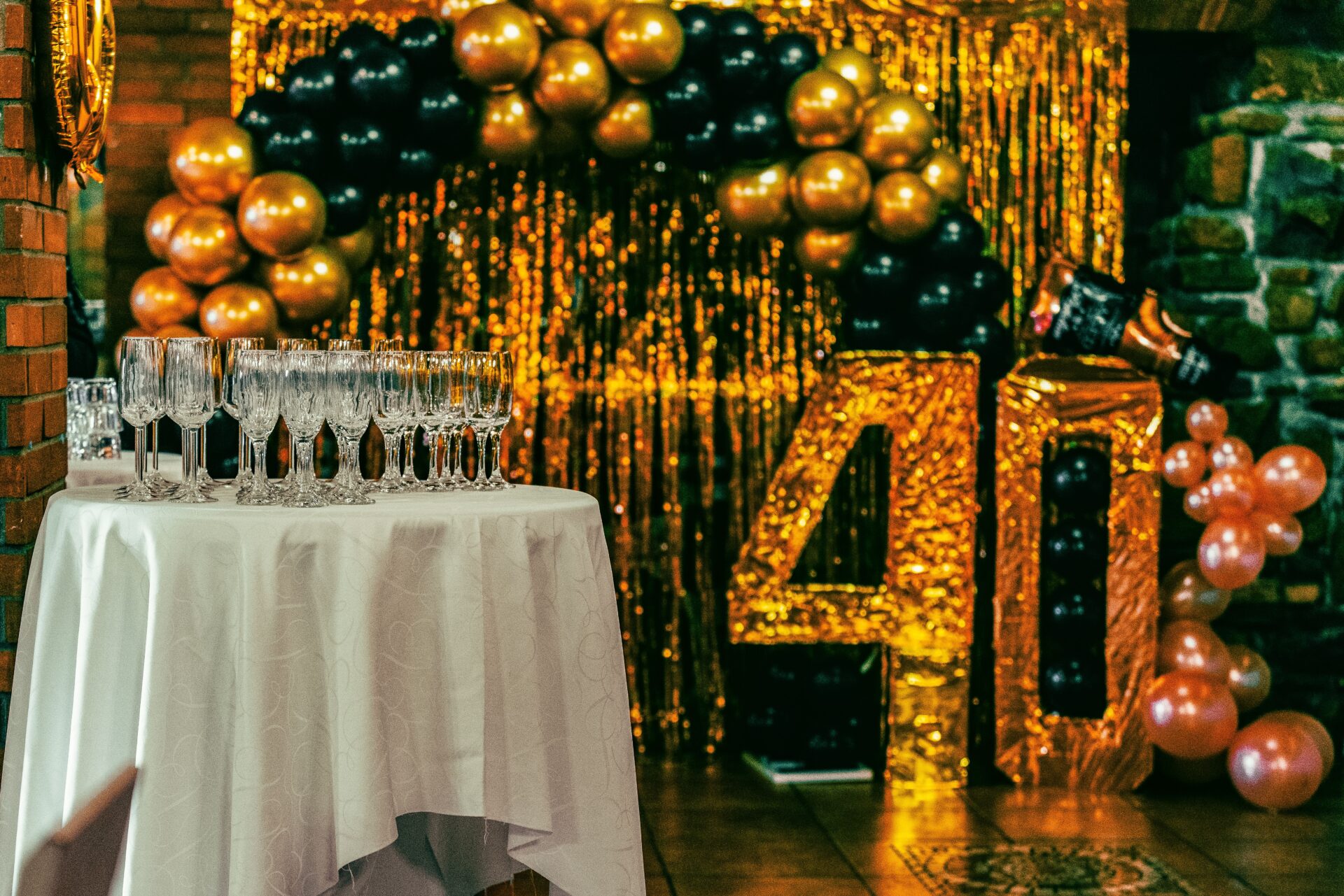 BACKDROPS 2 Chic 40th birthday party setting with champagne flutes, balloons, and gold glitter backdrop.