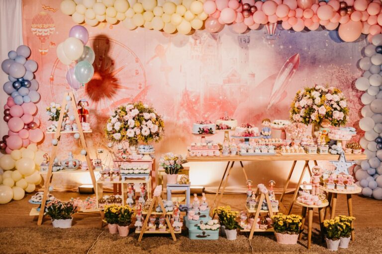 Wedding composition with colorful balloons over banquet table with appetizing desserts and flowers