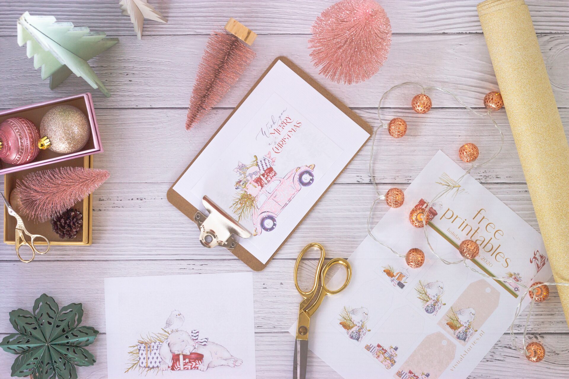 Home 12 Flat lay of festive pastel holiday crafting materials including cards, ornaments, and gift wrap.