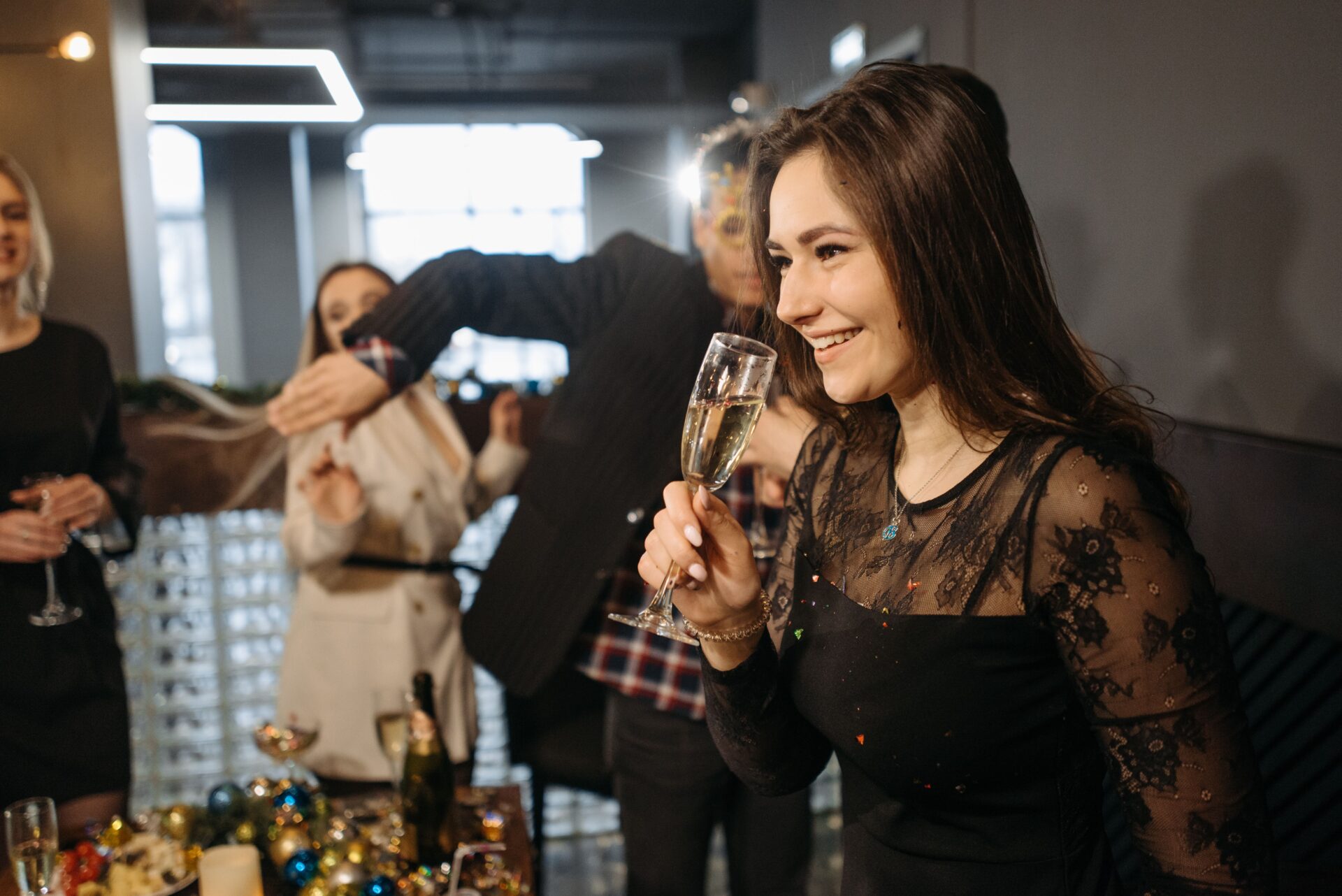 A lively office party with colleagues celebrating and clinking champagne glasses in a festive atmosphere.