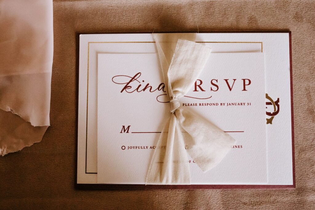 Top view of wedding invitation card for guest with RSVP abbreviation requiring respond from invitee