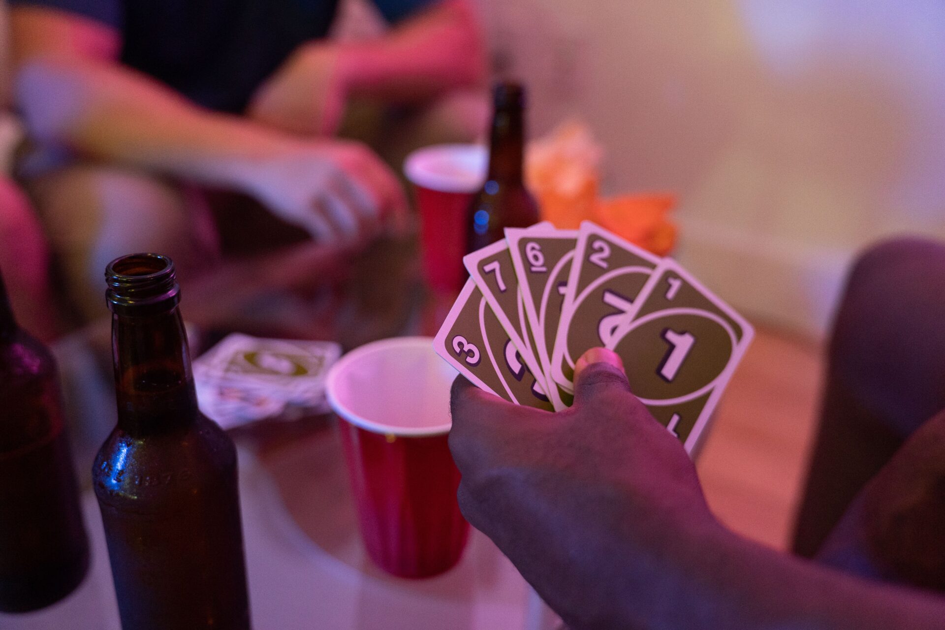 Home 11 Friends enjoying a game of Uno with drinks and snacks, creating a lively party atmosphere.